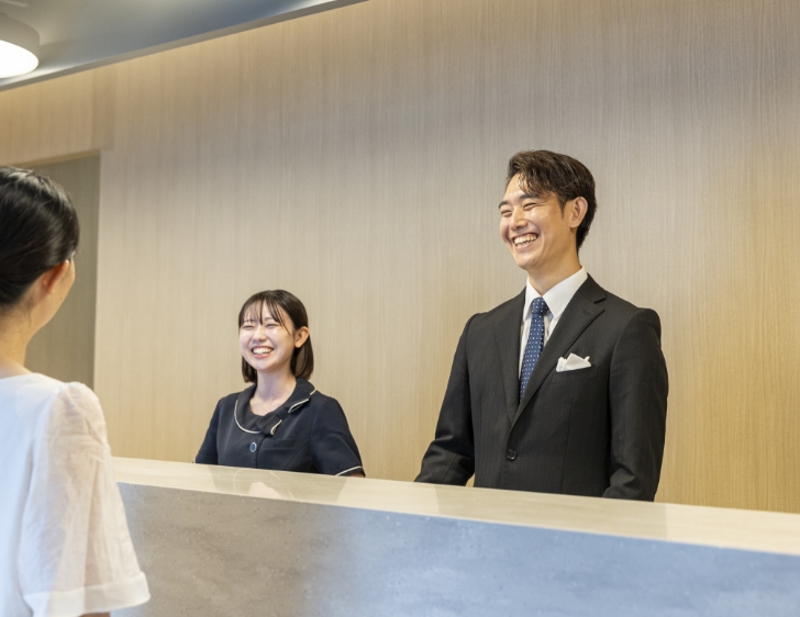 歯科医院の受付で笑顔で患者を迎えるスタッフ