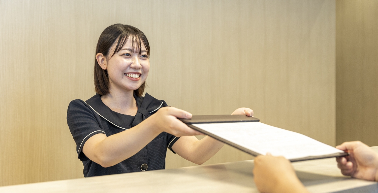 歯科医院の受付で患者を案内するスタッフ
