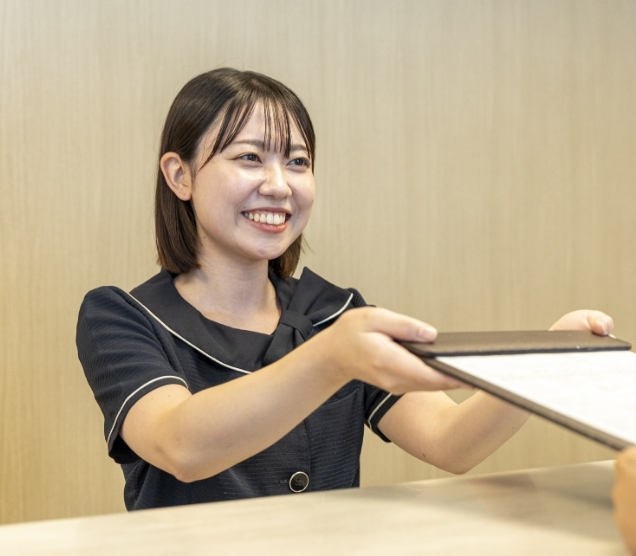 歯科医院の受付で患者を案内するスタッフ
